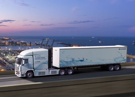 Hyundai XCIENT Fuel Cell Tractor running next to an industrial complex