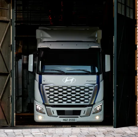 Two truck drivers standing in front of Hyundai XCIENT Fuel Cell Truck